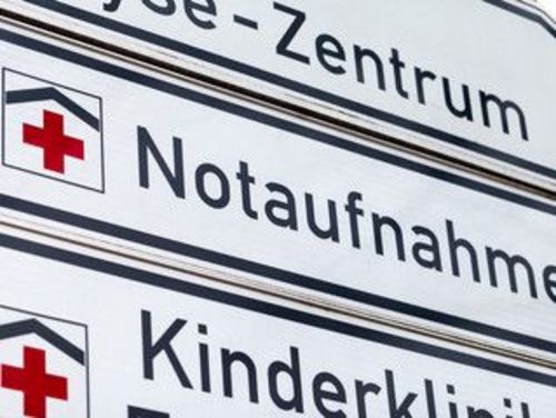 Zahrleiche weiß-schwarze Verkehrshinweischilder mit Hinweisen wie "Notaufnahme" oder "Kinderklinik"