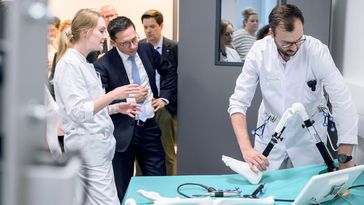 Falko Mohrs lässt sich von einer Ärztin etwas erklären und schaut einem Arzt dabei zu, wie er ein künstliches Kniegelenk positioniert.