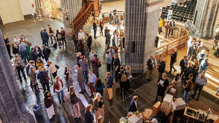 Viele Menschen stehen in einer Kirche und unterhalten sich.