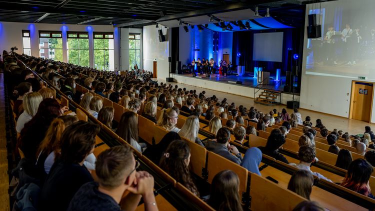 Voll besetztes Audimax: Die Studierenden folgen dem Programm auf der Bühne. 