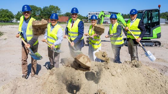 Menschen mit Spaten werfen Sand.