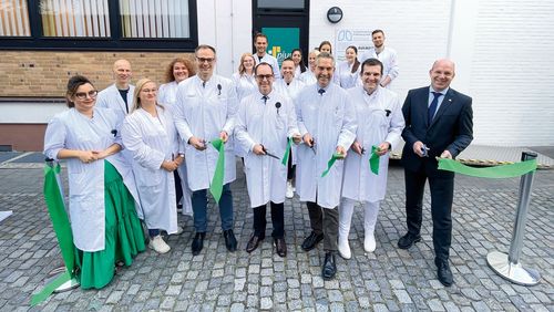 Gruppenfoto der Schülerinnen und Schüler sowie Dozentinnen und Dozenten der neuen Schule. Sie haben ein grünes Band zerschnitten.