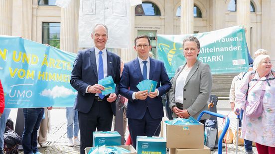 Die genannten Personen stehen vor dem Landtag in Hannover. Hinter ihnen Transparente der Landfrauen und der Kampagne Ärztinnen und Ärzte fallen nicht vom Himmel - außerdem ein schwebender Arztkittel.