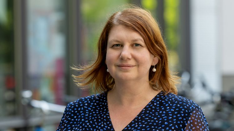 Porträtbild von Yulia Golub. Sie hat halblange dunkle Haare und trägt ein blaues Oberteil.